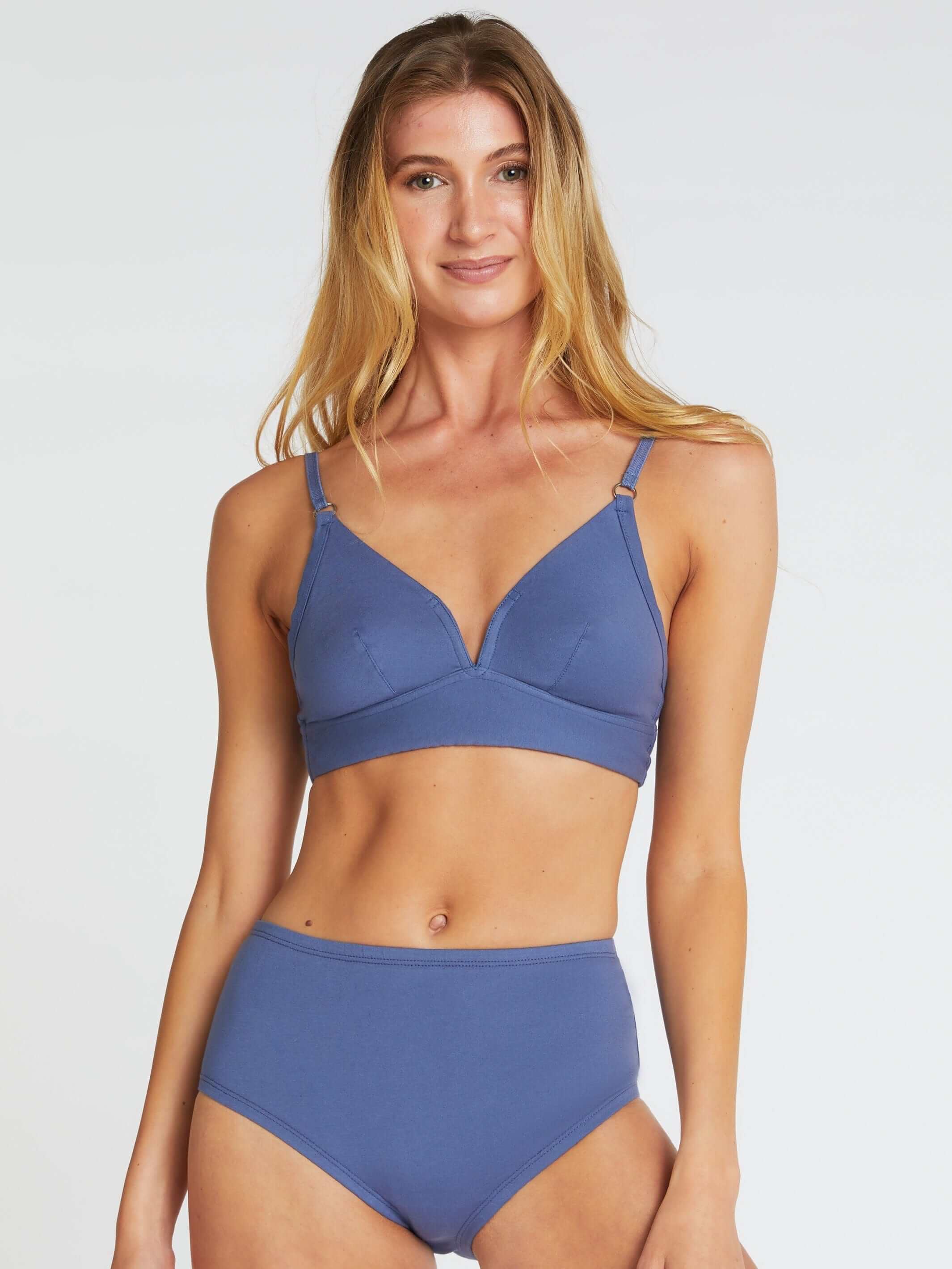 woman wearing blue bra with matching high waisted briefs in organic cotton