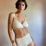 woman wearing high waisted briefs in cream organic cotton with matching bra